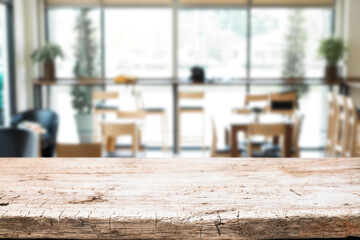 Empty wooden desk space platform over blurred restaurant or coffee shop background for product display montage.