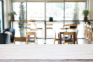 Empty wooden desk space platform over blurred restaurant or coffee shop background for product display montage.