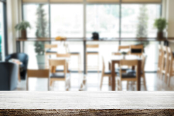 Empty wooden table space platform and blurred restaurant or coffee shop background for product display montage.