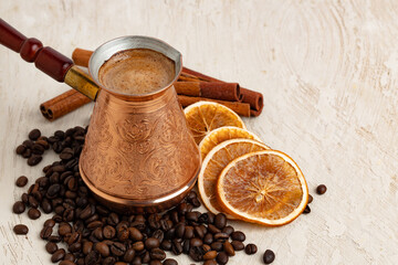 Obraz na płótnie Canvas Close up of copper coffee turk on light textured surface