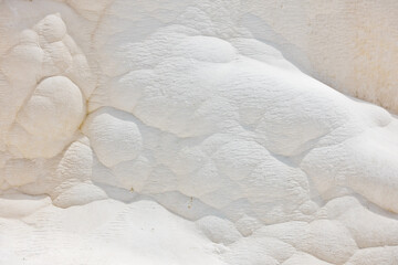 Details of white carbonate mineral rocks made by water flow at Pamukkale near archelological site...