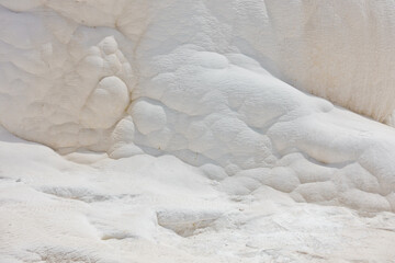 Details of white carbonate mineral rocks made by water flow at Pamukkale near archelological site Hierapolis, Denizli, Turkey