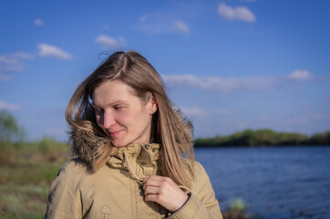 Portrait of embarrassed woman on the background of the river