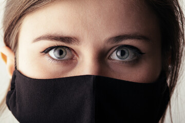 part face of sad young woman in a black stylish mask , fashion and life 2020 under quarantine and epidemic,