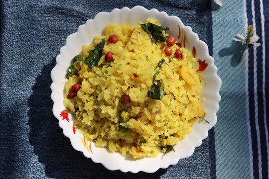 Poha or Kanda Poha popular Maharashtrian breakfast recipe made from red or white flattened rice, potatoes, onions, herbs and spices. 