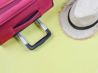 Travel concept , Top view of travel accessories ; pink suitcase handle and hat  on  yellow background