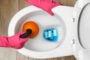 Women cleaning clogged toilet. broken overflowing toilet. home cleaning service concept.