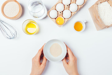 Female hands holding bowl of dry active yeast