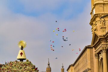 Children's balloons flying free over the Virgen del Pilar full of flowers on the day of the flower...