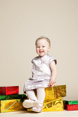 little girl sitting on boxes with gifts. celebration of birthday or new year.