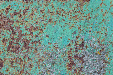 the surface of the old metal, pitted with rust, covered in old green paint