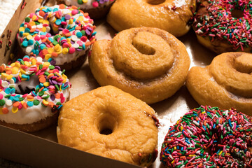 close up of freshly baked doughnuts with sprinkles and different fillings