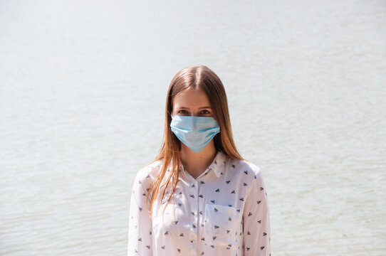 Woman In A Mask On A Background Of Water. Travel And Leisure In Covid 19 And Quarantine Restrictions