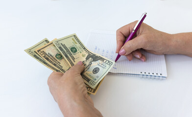 Closeup senior female hands counting dollars money sitting at the table. US paper notes.