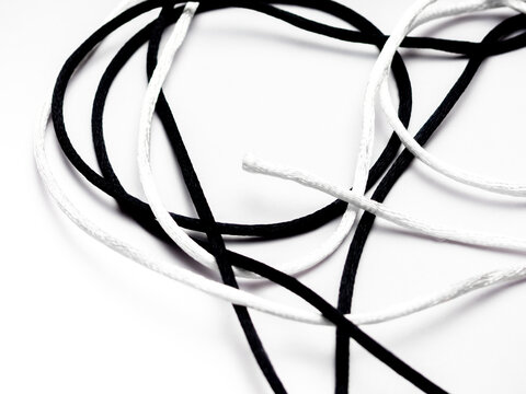 A knot with a white thread and a black thread against a white background