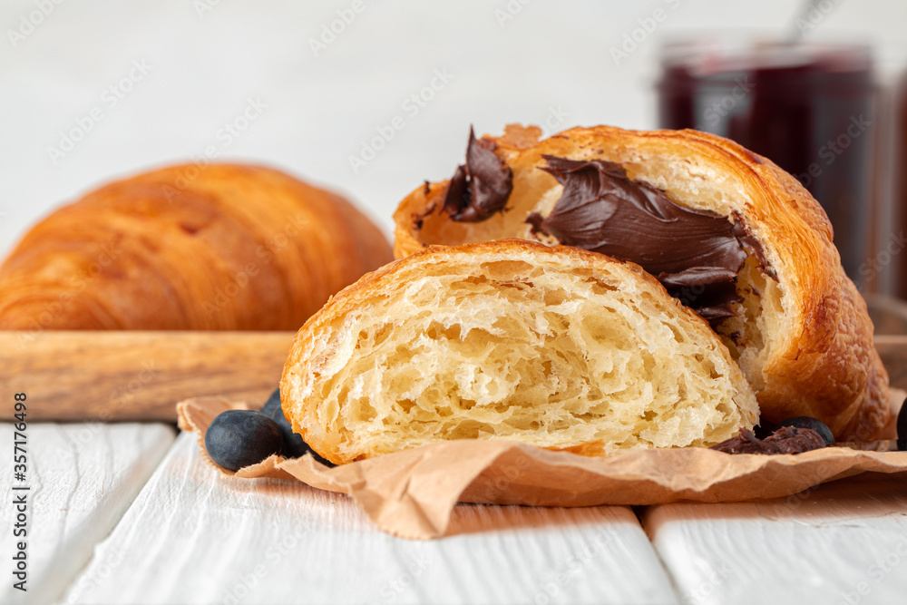 Wall mural fresh baked croissant on wooden table close up