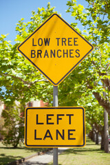 Road sign. Low tree branches. Left lane. Australia, Melbourne.

S