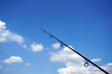 Fishing rod and cloudy blue sky background