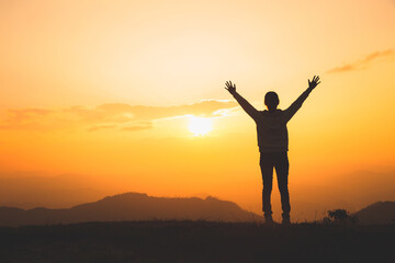 Man rise hand up on top of mountain and sunset,  Freedom and travel adventure concept. Religious beliefs, Copy space.