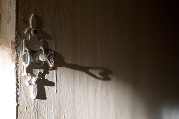 Metalic carved latch close-up on a battered white-painted wooden door. Shadow in the form of a heart. Vintage.