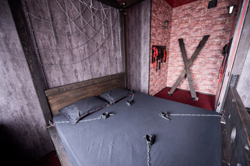 Torture of Andreev cross on the bedroom wall. VDSM equipment and sex toys. Leather handcuffs with a...