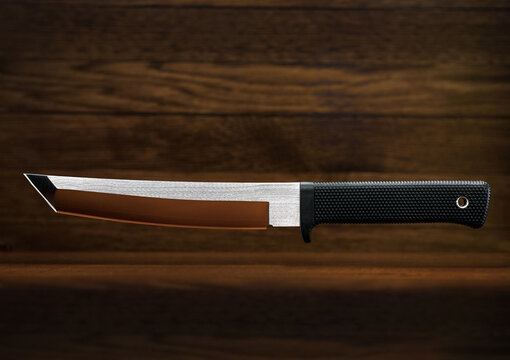 Tanto knife wooden background