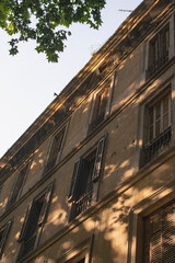 typical Barcelona apartment building with sunlight and trees vertical