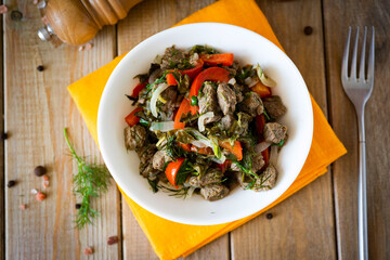 Beef stewed with vegetables on a beautiful plate on a wooden table