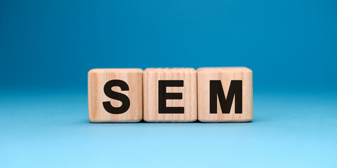 SEM word cube on a blue background. Business concept.