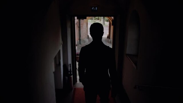 Man goes down the stairs in the castle, groom goes to his bride, silhouette of a man