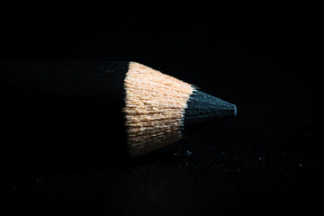 A macro shot of a black pencil tip in a dark background