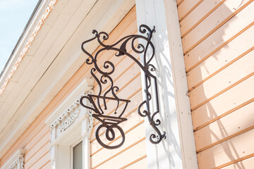 Kafe forged symbol, cup sign on the rustic, vintage building. Tourism to Europe or Russia. 