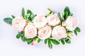 Floral peonies arrangement . Artificial tender white pinkish peony flower with leaves, flat composition on a light background. top view place for text