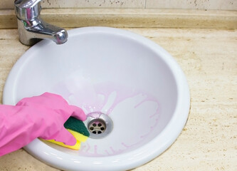 Woman doing chores cleaning bathroom at home.