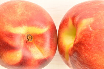 Ripe juicy organic nectarine, close-up, on a painted wooden table.