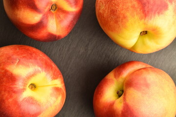 Ripe juicy organic nectarine, close-up, on a serving plate of slate.