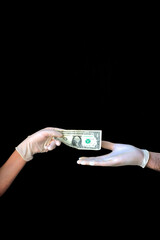 Two hands with medical gloves paying with a one Dollar bill on black background.