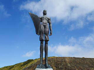 Statue of a surfer in the beach of Ribeira d’Ilhas World Surf Reserve. Ericeira in Portugal.