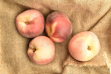 Ripe organic peach, close-up, on jute fabric.