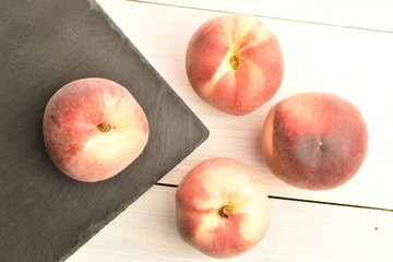 Ripe organic peach, close-up, on a white painted table.