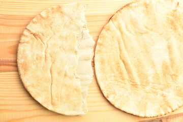 Fresh aromatic pita, close-up, on a wooden table.