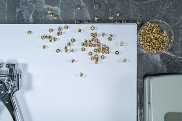 rivets scattered on a white sheet lying on a gray marble table