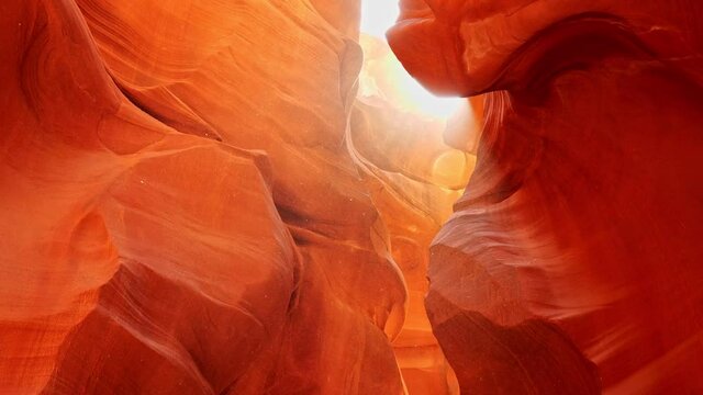 Dust flies in the sun in antelope canyon. Zoom out shot of red walls of Antelope Canyon in Arizona, USA