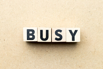 Letter block in word busy on wood background