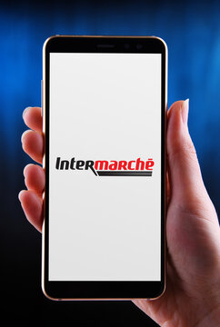 Hands holding smartphone displaying logo of Intermarche