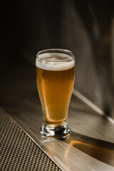 one full beer glass white foam on the bar stand. High quality photo