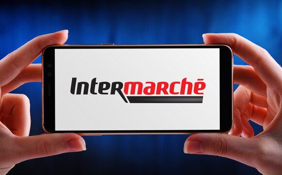 Hands holding smartphone displaying logo of Intermarche