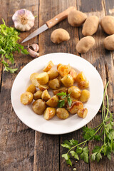 roasted potato with parsley on wood background