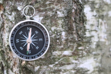 round compass on natural background as symbol of tourism, travel and outdoor activities