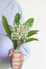 man holding lily of valley flower bouquet 